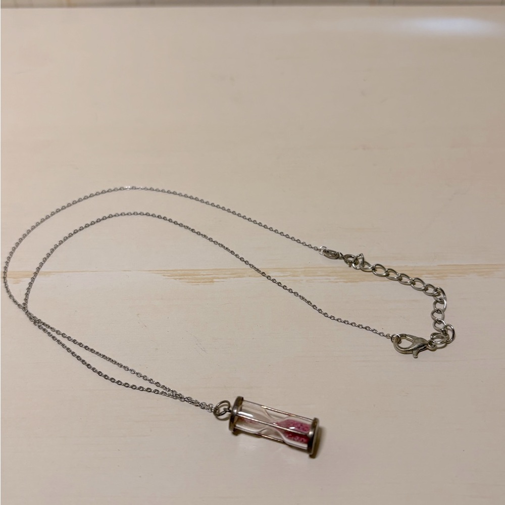 Silver tone necklace with a working hourglass.